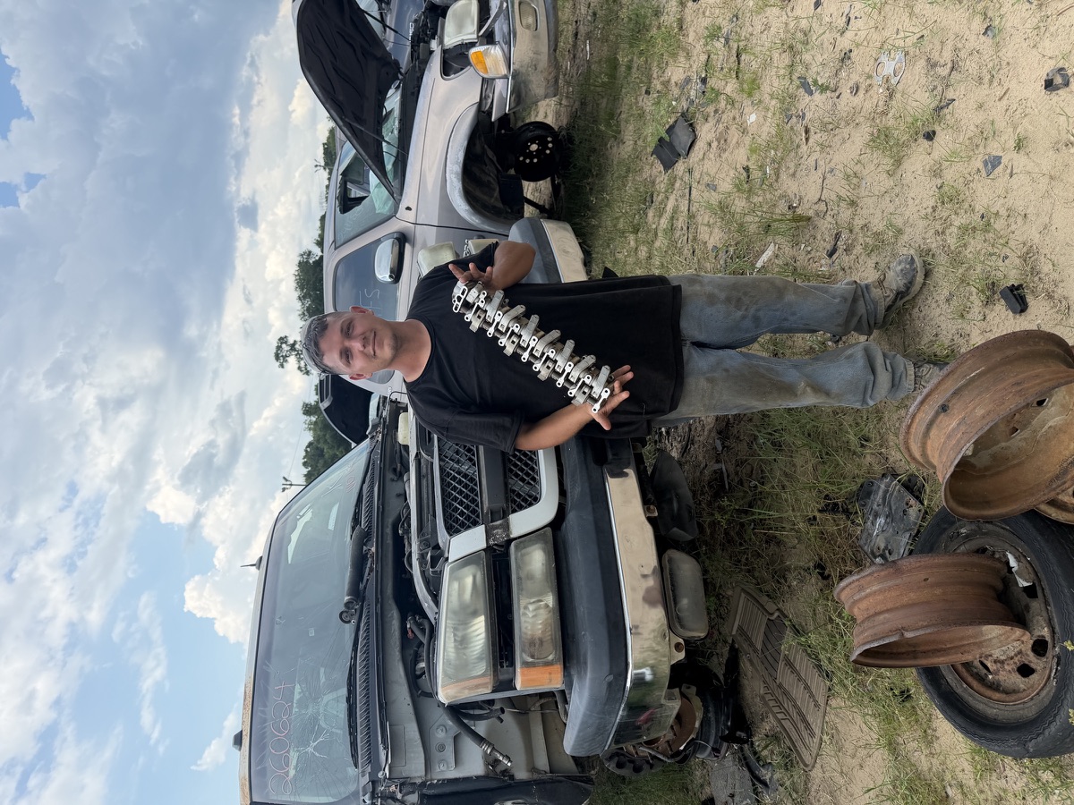 Kiker's customer holding a part pulled in the self-service yard